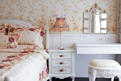 長親房內以及腰的白色線板延伸出床頭櫃設計，再搭配小碎花壁紙由濃而疏地由下往上延伸的設計，使空間