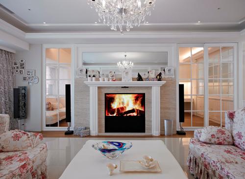 鄉村風格講求對稱感，透過玻璃窗欞玻璃及壁爐設計，將客廳的大器舒適感營造出來。壁爐上方的鏡面更