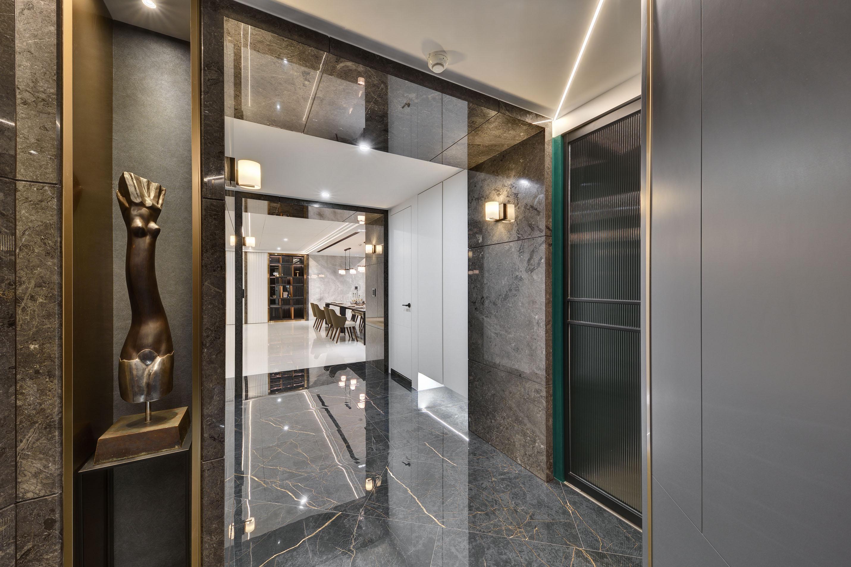 以石材及金屬分割牆面，搭配高雅的展示檯面，營造出大器的入口意象