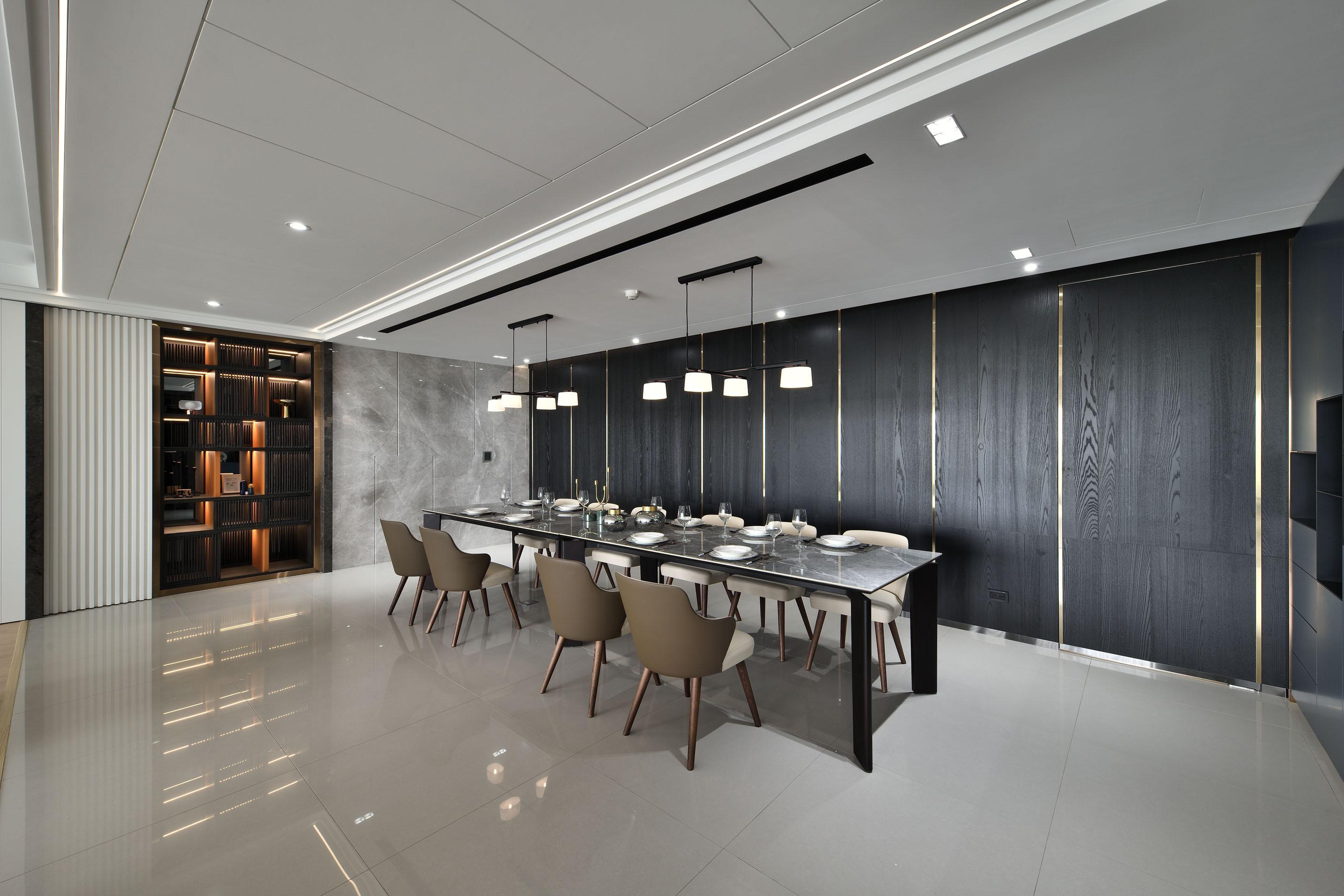 用餐空間與閱讀空間被金屬鑲嵌的黑色質感木紋與活潑跳色拼接牆面包圍，低調紳士風