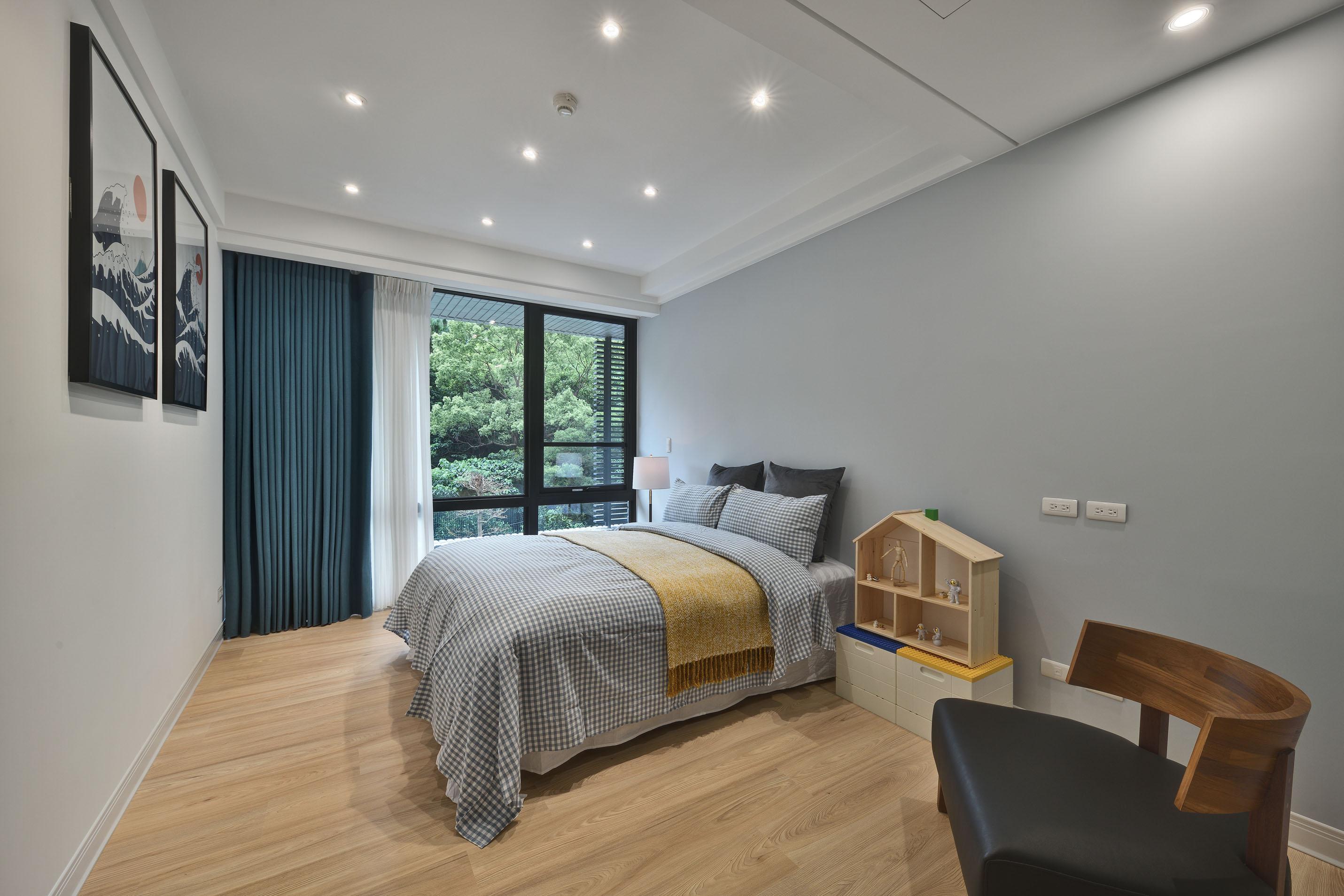 男孩房以不同明度的藍色為基底，點綴部分黃色系及木紋，使空間具活潑與溫馨感