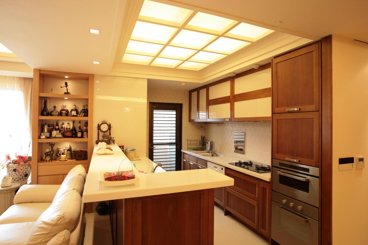 餐廳吧台底端為建築結構的柱子，在客廳的那一面使用茶鏡包覆，消解掉視覺上的障礙，吧台側則利用